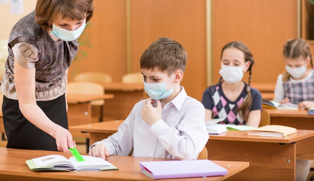 Children and a teacher wear N95 face masks in school.