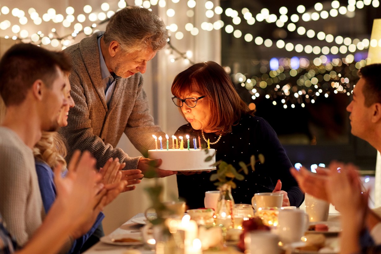 a woman blowing the birthday candles