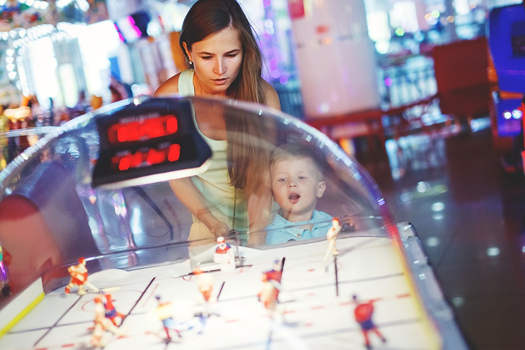 Parent and toddler playing on dome hockey table