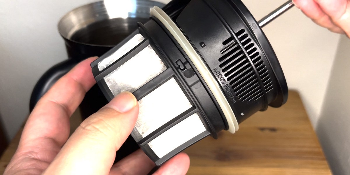 Hand holding top part of French press