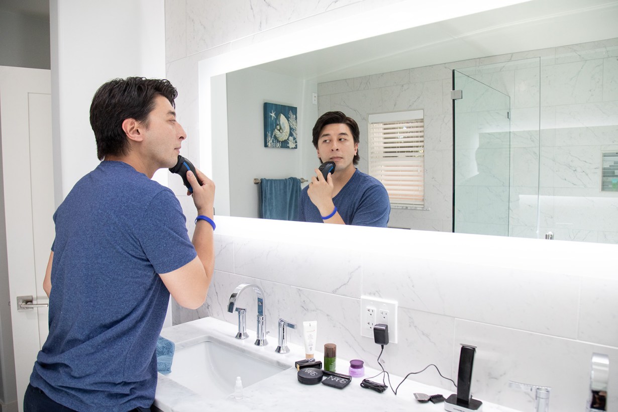 a man shaving in front of a mirror