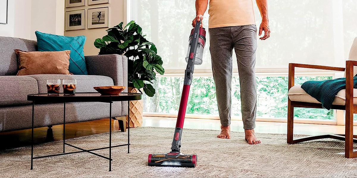 Person using Shark Anti-Allergen Pet Power Cordless Stick Vacuum on carpet