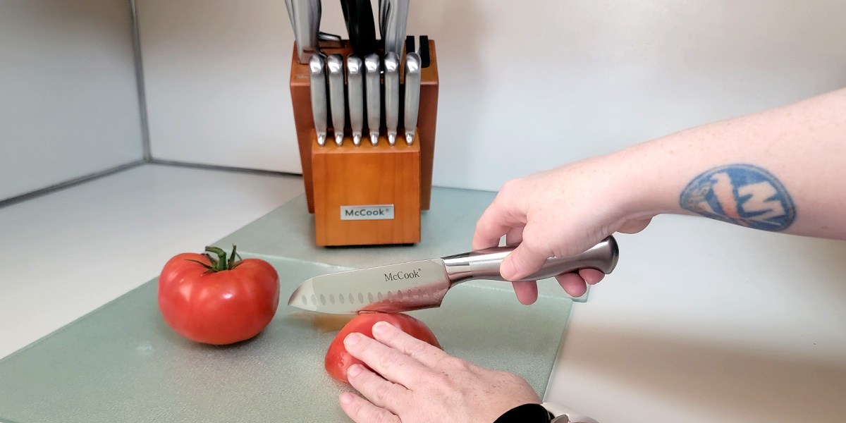 McCook Knife Set on kitchen counter with hand using knife to slice tomato in front McCook Knife Set on kitchen counter with hand using knife to slice tomato in front