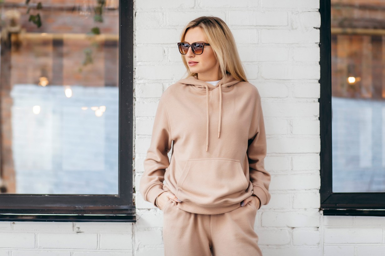 a woman in a pink hoodie and sunglasses
